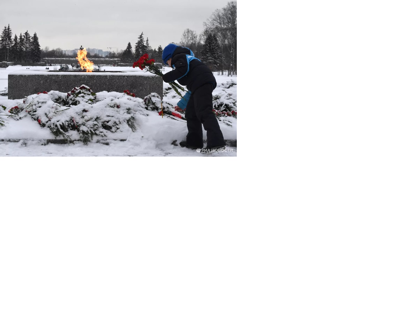 Мальчик возлагает цветы к вечному огню у монумента &amp;quot;Мать-Родина&amp;quot; на Пискаревском мемориальном кладбище в память о погибших в годы блокады.